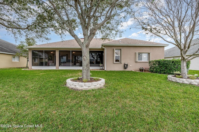 rear view of property with a sunroom and a lawn