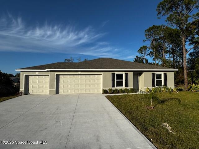 single story home featuring a garage and a front lawn