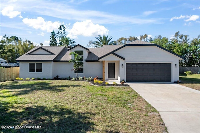 ranch-style house featuring a garage and a front lawn