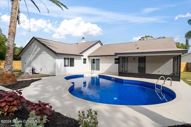 view of pool with a sunroom and a patio area