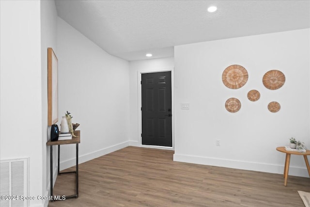 foyer entrance featuring hardwood / wood-style flooring and a textured ceiling