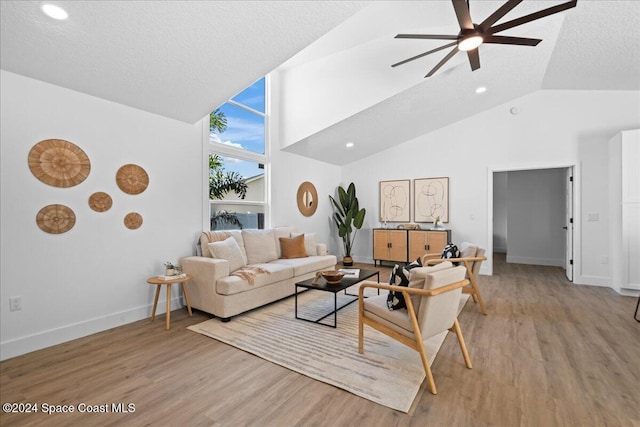 living room with a textured ceiling, high vaulted ceiling, light hardwood / wood-style flooring, and ceiling fan