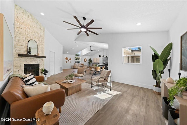 living room featuring a wealth of natural light, a fireplace, lofted ceiling, and light wood-type flooring