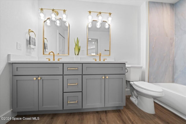 bathroom with hardwood / wood-style floors, a bathing tub, toilet, and vanity