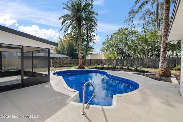 view of pool with a patio and a sunroom