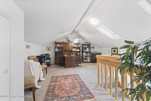 office with a textured ceiling, light colored carpet, ceiling fan, and vaulted ceiling with skylight