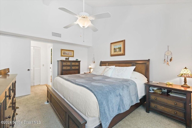 carpeted bedroom featuring ceiling fan, a closet, and vaulted ceiling