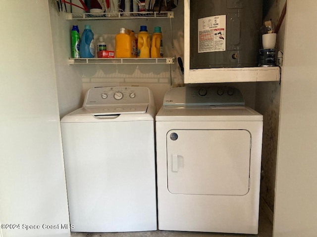 laundry room with water heater and washer and clothes dryer