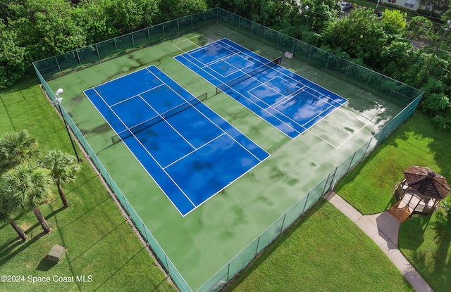 view of sport court with a yard