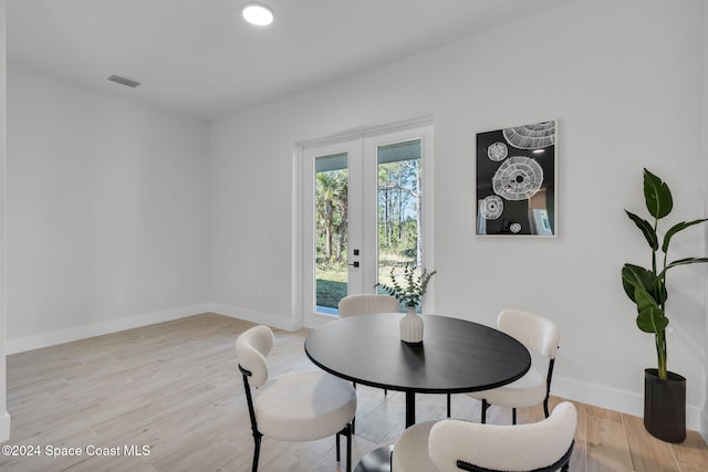 dining room featuring light wood-type flooring and french doors