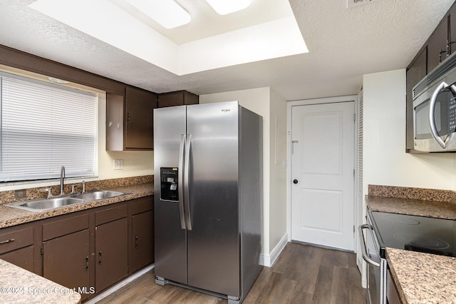 kitchen featuring appliances with stainless steel finishes, dark hardwood / wood-style flooring, a textured ceiling, and sink