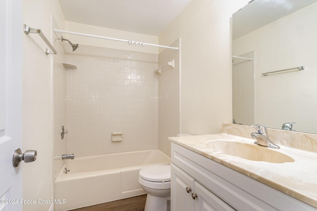 full bathroom featuring hardwood / wood-style flooring, vanity, toilet, and tiled shower / bath