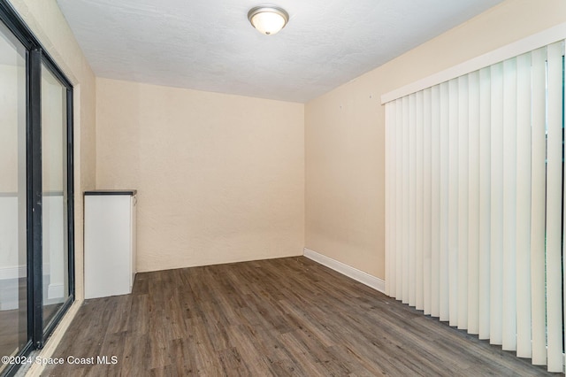 unfurnished room with dark hardwood / wood-style floors