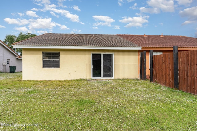 rear view of house featuring a lawn