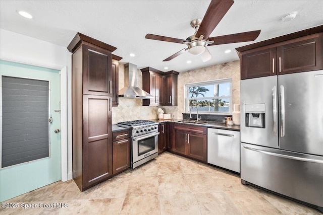 kitchen featuring ceiling fan, tasteful backsplash, sink, stainless steel appliances, and wall chimney exhaust hood