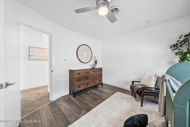 sitting room with dark wood-type flooring and ceiling fan