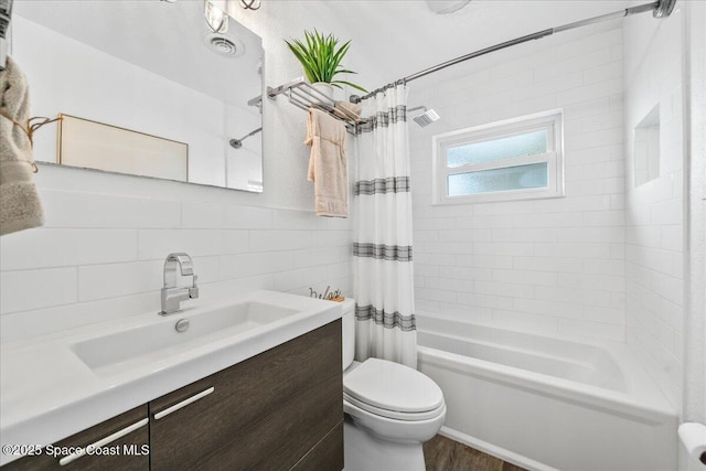 full bathroom with toilet, vanity, tile walls, backsplash, and shower / bath combo with shower curtain