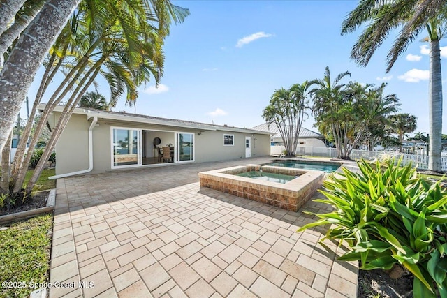 exterior space with an in ground hot tub and a patio area