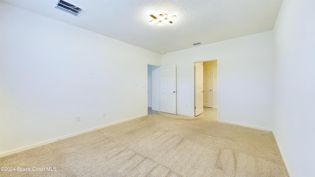 carpeted spare room featuring a textured ceiling