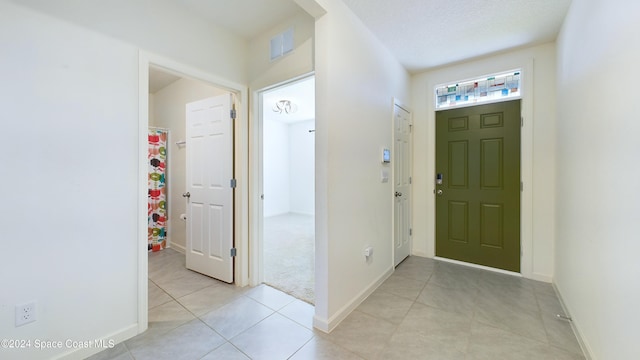 foyer with light tile patterned floors and a textured ceiling