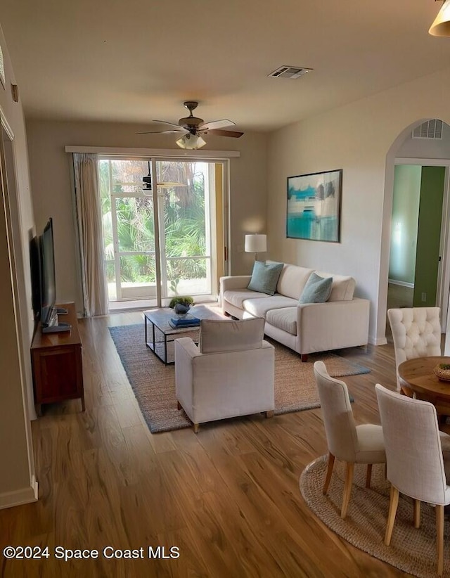 living room featuring light hardwood / wood-style flooring and ceiling fan