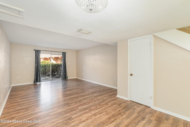 unfurnished room featuring a chandelier and hardwood / wood-style floors