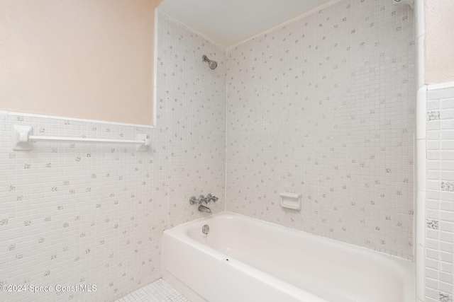 bathroom with tile patterned flooring, tiled shower / bath combo, and tile walls