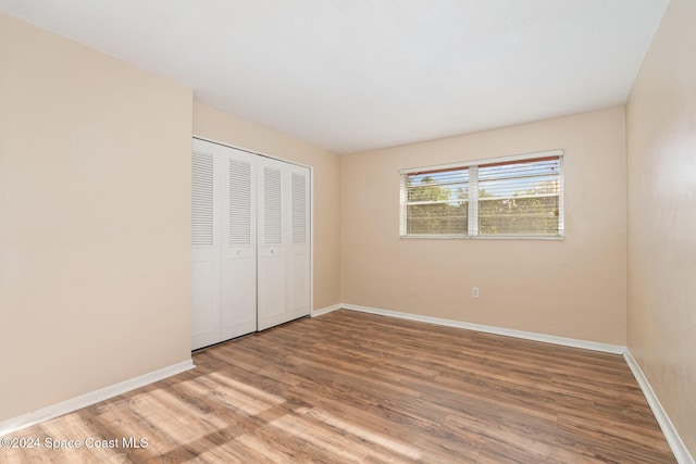 unfurnished bedroom with wood-type flooring and a closet