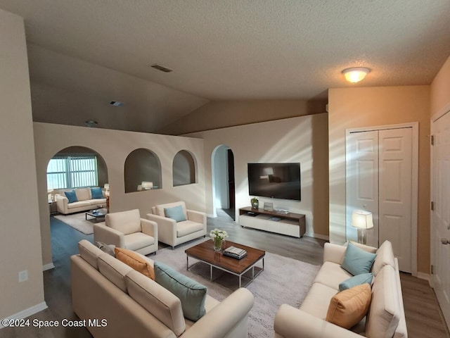 living room featuring hardwood / wood-style floors and vaulted ceiling