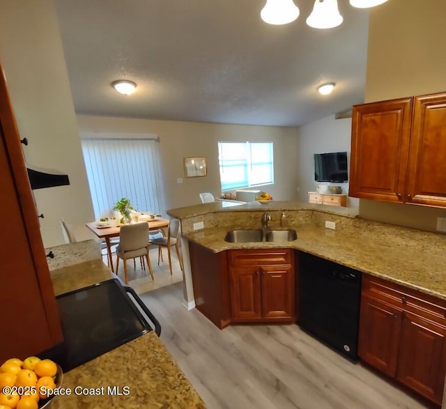 kitchen with black dishwasher, light stone counters, a peninsula, light wood-style floors, and a sink