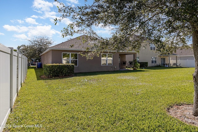 back of house featuring a lawn