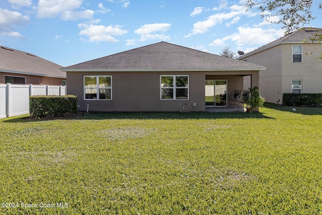 back of property featuring a lawn