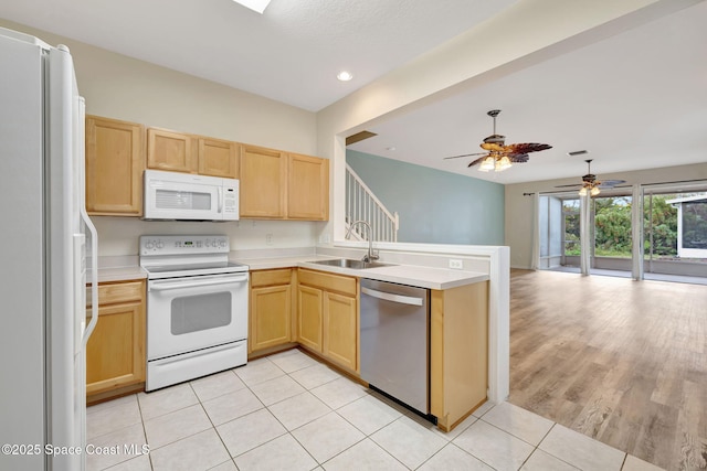 kitchen with sink, white appliances, light tile patterned flooring, and light brown cabinets