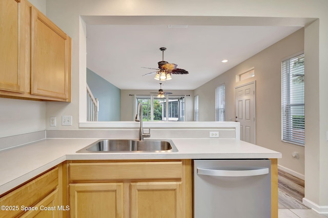 kitchen with light brown cabinets, sink, kitchen peninsula, stainless steel dishwasher, and light hardwood / wood-style flooring