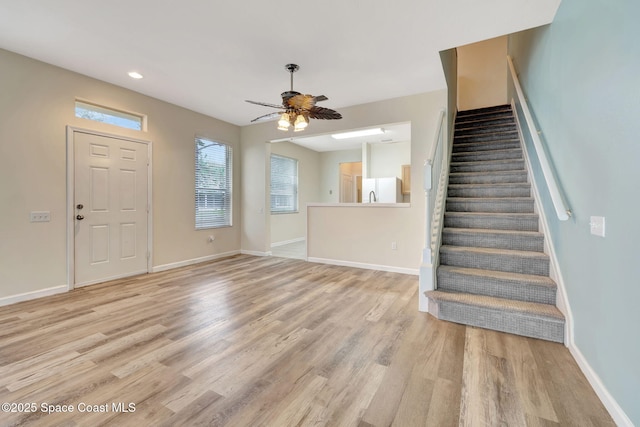 foyer entrance with light hardwood / wood-style flooring and ceiling fan