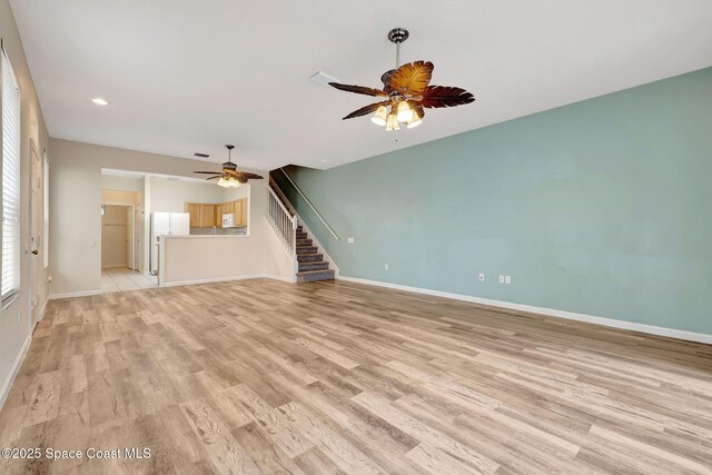 unfurnished living room with light hardwood / wood-style flooring and ceiling fan