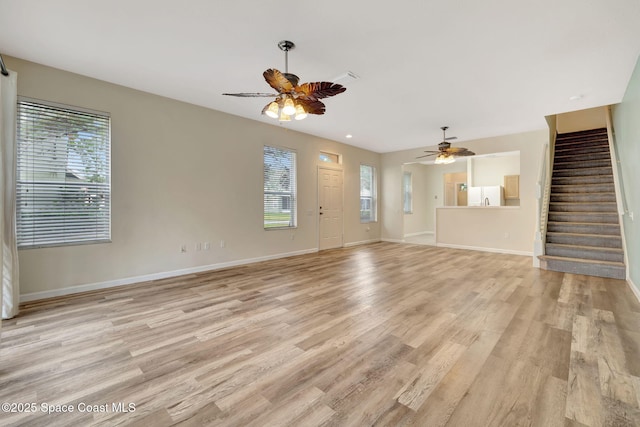 unfurnished living room featuring ceiling fan, light hardwood / wood-style flooring, and a healthy amount of sunlight