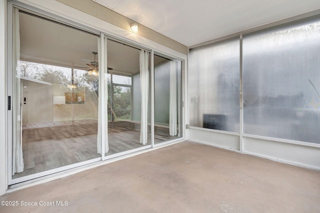 unfurnished sunroom with ceiling fan