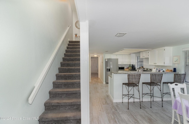 stairway with hardwood / wood-style floors and sink