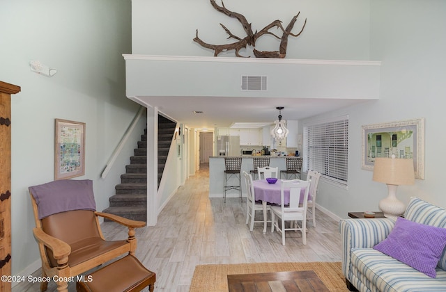 interior space with a towering ceiling and light hardwood / wood-style floors