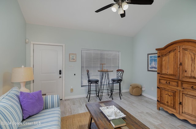 living room with light hardwood / wood-style floors, vaulted ceiling, and ceiling fan