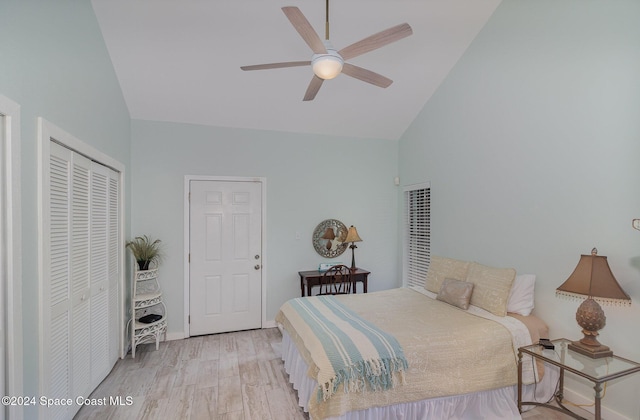 bedroom featuring ceiling fan, a closet, high vaulted ceiling, and light wood-type flooring