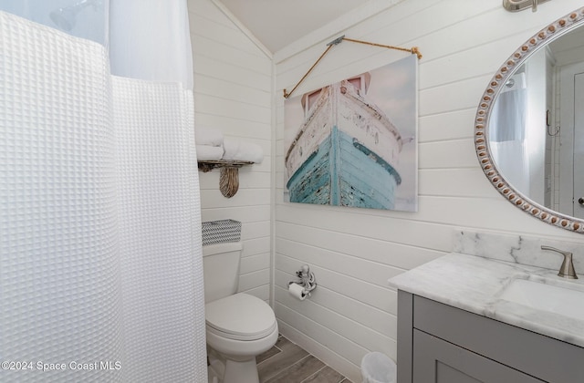 bathroom featuring walk in shower, vanity, vaulted ceiling, wood-type flooring, and toilet