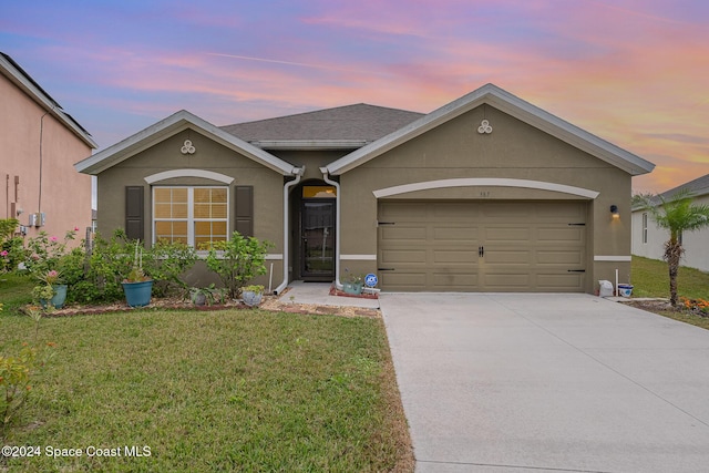 ranch-style home with a lawn and a garage