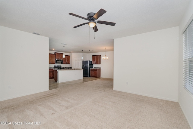 unfurnished living room featuring a textured ceiling, ceiling fan with notable chandelier, and light carpet