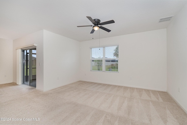 empty room with ceiling fan and light colored carpet