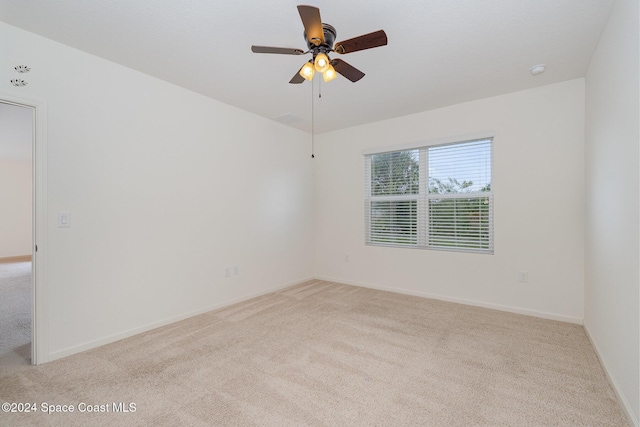 carpeted spare room featuring ceiling fan