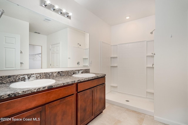 bathroom featuring tile patterned floors, vanity, and a shower