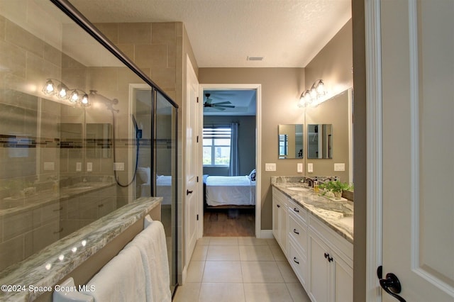 bathroom featuring ceiling fan, tile patterned flooring, a textured ceiling, vanity, and a shower with shower door