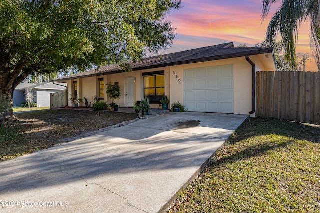 single story home with a garage and a lawn